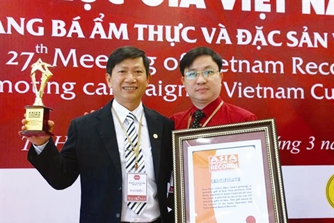 Le médecin Phùng Tuân Giang (droite) reçoit le certificat de «Médecin qui a soigné beaucoup de malades de divers pays par la médecine traditionnelle du Vietnam».