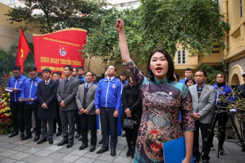 Нгуен Май Ань дает клятву перед знаменем Компартии на церемонии вступления на ряды коммунистов. (Фото: Минь Шон/Vietnam+)