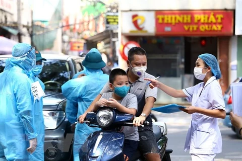 Медицинский персонал инструктирует людей в очереди на тестирование. (Фото: Минь Кует /Vietnam+)