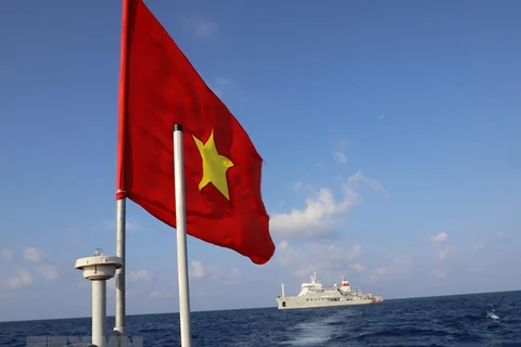 Национальный флаг развевается на крыше катера, перевозящего солдат с корабля Truong Sa 571 на остров Шонгтытэй. (Фото: ВИА)