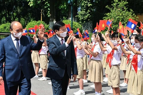 Президент Вьетнама Нгуен Суан Фук (слева) и генеральный секретарь ЦК Лаосской народно-революционной партии, президент Лаоса Тонглун Сисулит на церемонии встречи в Ханое 28 июня (Фото: ВИА)