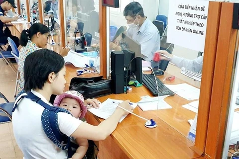 Работники осуществляют процедуры получения пособия по страхованию от безработицы. (Фото: Vietnam+)