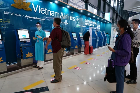 Пассажиры могут самостоятельно зарегистрироваться онлайн в киосках, развернутых Vietnam Airlines в 6 внутренних аэропортах, чтобы уменьшить контакты во время эпидемии COVID-19. (Фото: Vietnam+)