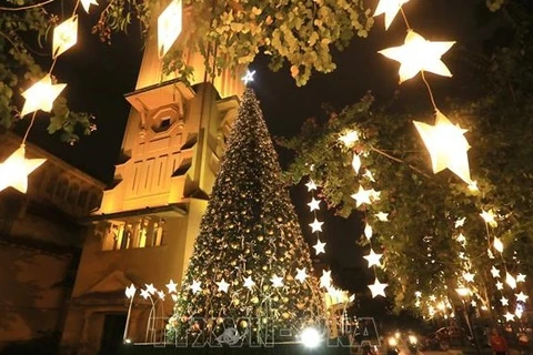 Большая елка искусно украшена сияющими звездными огнями перед церковью Кыабак накануне Рождества. (Фото: ВИА)