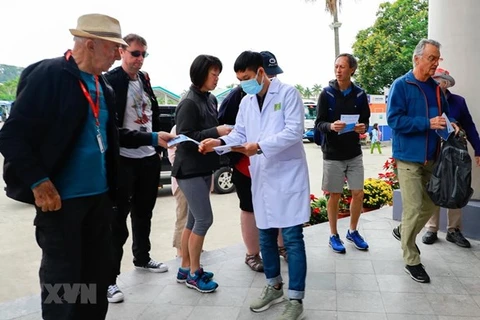 Медицинский работник раздает листовки о nCoV посетителям залива Халонг, провинция Куангнинь. (Фото: ВИА)