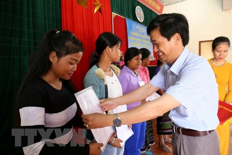 Представитель компетентного ведомства провинции Куангчи вручает решение о приеме во вьетнамское гражданство жителям в пограничном районе Вьетнама и Лаоса. (Фото: Нгуен Ли/ВИА)