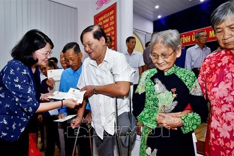 Вице-президент Данг Тхи Нгок Тхинь (слева) вручает подарки получателям социальной помощи в Камау (Фото: baoanhdatmui.vn)