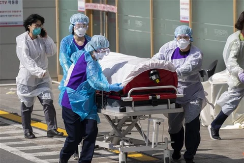 Медработники доставляю пациентов с COVID-19 в больницу в Тэгу, Южная Корея, 4 марта. Фото: (Синьхуа/ВИА)