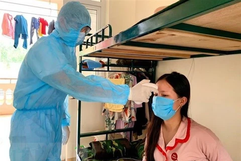 Проверка температуры пациента на карантине в Ханое (Фото: ВИА)