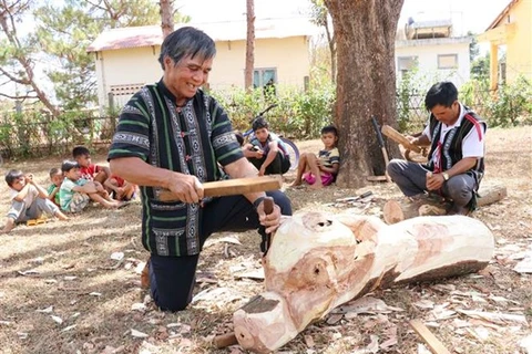 Мастер Ксор Кро и молодые свои ученики – продолжатели ремесла по изготовлению деревяных скульптур. (Фото: Хонг Диеп/ВИА)
