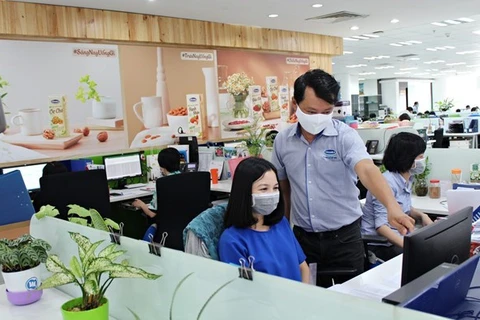 Сотрудники Vinamilk носят маски во время вспышки COVID-19. (Фото: Vinamilk)