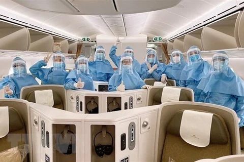 Пилоты и бортпроводницы Vietnam Airlines одевают защитные защитную одежду, перчатки, маски, очки, при себе также носят салфетки на спиртовой основе и дезинфицирующий раствор. (Фото: ВИА)