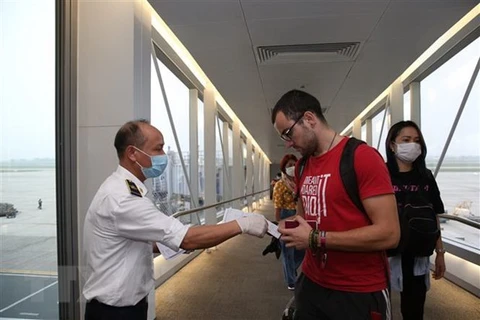 Проверка мелицинской декларации пассажиров до въезда в международный аэропорт Нойбай 7 марта. (Фото: Зыонг Жанг/ВИА)