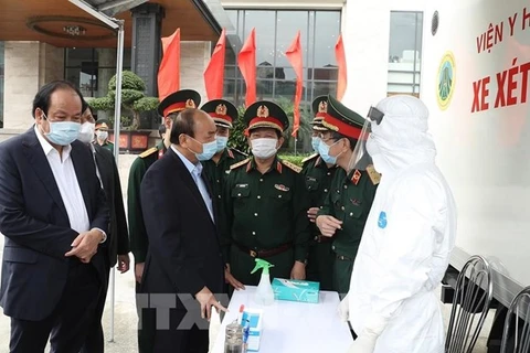 Премьер-министр Нгуен Суан Фук (второй слева) посещает мобильную тест-станцию SARS-CoV-2 медицинского института армии (Фото: ВИА)