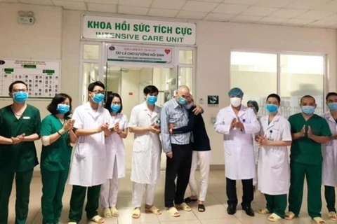 Супруги британских пациентов (в черно-белом) и медперсоналы Национальной больницы тропических болезней. (Фото: корр/Vietnam+)