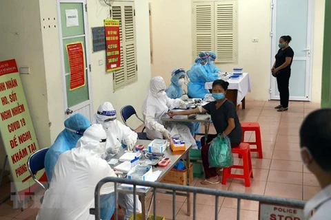 Медицинские работники собирают образцы у Ханойских жетелей для проведения тестов на COVID-19 (Фото: ВИА)