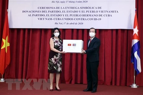 Министр строительства Фам Хонг Ха (справа) вручает сертификат помощи кубинскому послу во Вьетнаме Лианису Торресу Ривере (Фото: ВИА) 