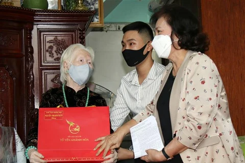 Председатель НС Вьетнама Нгуен Тхи Ким Нган вручает подарок матери-героине. (Фото: ВИА)