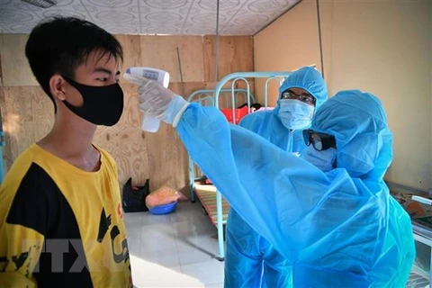 Медицинские работники измеряют температуру тела и проверяют здоровье граждан в карантинных зонах города Хатиен (Киенжанг). (Фото: ВИА)