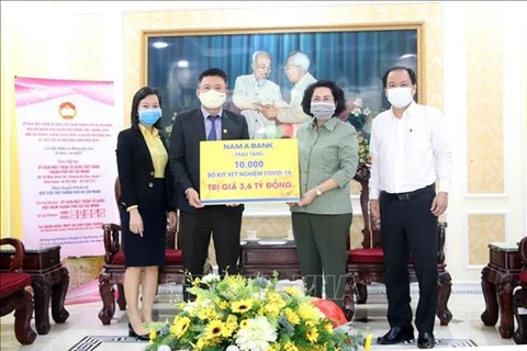 То Тхи Бить Чау (второй справа), председатель отделения Отечественного фронта Вьетнама города Хошимина, получает пожертвование от представителей бизнеса. (Фото: ВИА)