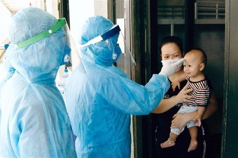 Проверка температуры тела в карантинном центре в районе Татьтхат в Ханое (Фото: ВИА)
