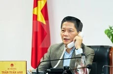 Министр промышленности и торговли Чан Туан Ань разговаривает по телефону (Фото: ВИА)