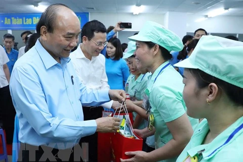 Премьер-министр Нгуен Суан Фук вручает подарки рабочим Foster Electronics Co., Ltd. (Вьетнам). (Фото: ВИА)