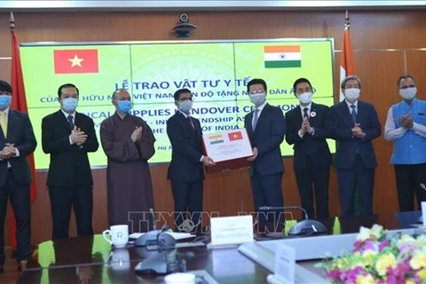Министр информации и коммуникаций Нгуен Мань Хунг (четвертый справа) вручает предметы медицинского назначения послу Индии во Вьетнаме Пранае Верме. (Источник: ВИА)