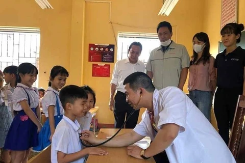Врач осматривает ученика начальной школы Тамфук в районе Виньтыонг, провинции Виньфук (Фото: ВИА)