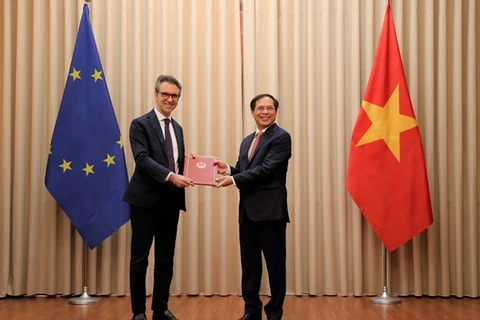 Заместитель министра иностранных дел Буй Тхан Шон (справа) вручает 18 июня дипломатические ноты главе делегации ЕС во Вьетнаме послу Джорджио Алиберти. (фото: ВИА)