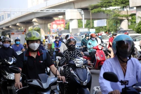 Ханойские мотоциклисты укутываются в одежду, чтобы защитить себя от летней жары. (Фото: ВИА)