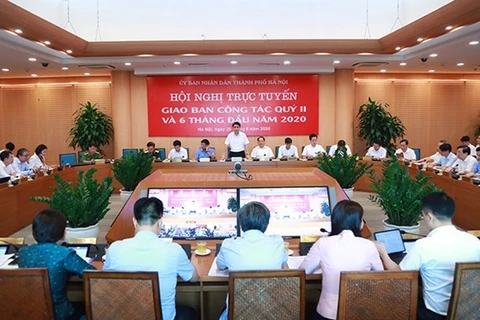 Председатель Народного комитета Ханоя Нгуен Дык Тьюнг (стоит) выступает на телеконференции (Источник: hanoi.gov.vn)
