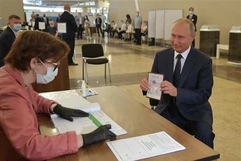 Президент России Владимир Путин (справа) на избирательном участке референдума по поправкам в Конституцию в Москве 1 июля 2020 года. (Фото: AFP/ВИА)