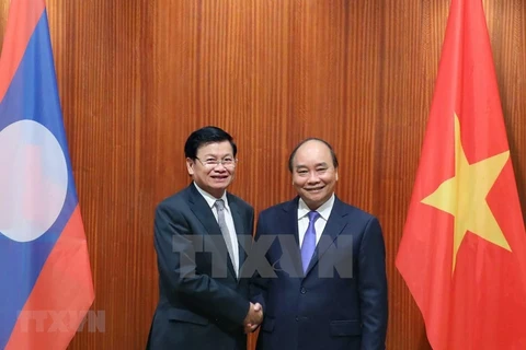 Премьер-министр Нгуен Суан Фук встречается со своим лаосским коллегой Тонглоном Сисулитом во время визита премьер-министра Лаосской Республики во Вьетнам 5 июля. (Фото: ВИА)