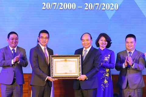 Премьер-министр Нгуен Суан Фук (третий, справа) вручает почетный сертификат за заслуги фондовой бирже города Хошимина на церемонии 20 июля (фото: ВИА)
