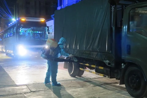 Работник проводит дезинфекцию транспортного средства, въезжающего в зону концентрированного карантина (Фото: ВИА)