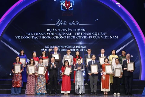 Председатель НС Нгуен Тхи Ким Нган (в первом ряду, пятая справа) вручает награды первым лауреатам 6-й Национальной премии внешнего информирования 28 июля (Фото: ВИА)