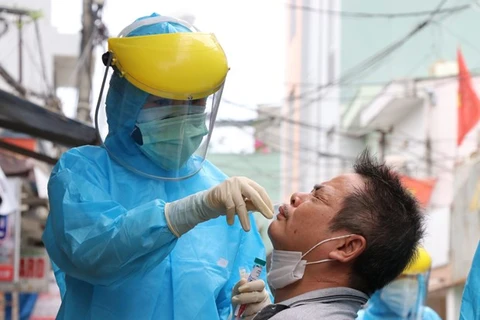 Медицинский работник берет мазок для тестирования COVID-19 у жителя района Сонча города Дананг (Фото: ВИА)