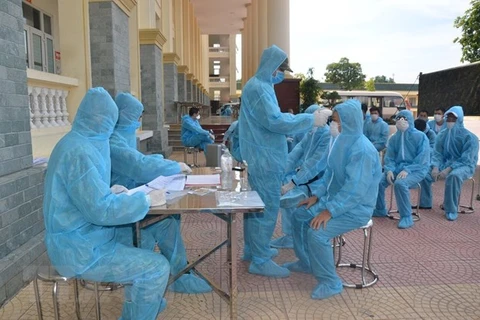 Персонал военного училища военного командования Ханоя проводит медицинские процедуры для граждан, находящихся на карантине. (Фото: ВИА)