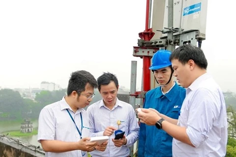 Рабочие проверяют услуги интернета в районе озера Хоанкьем в Ханое (Фото: ВИА)