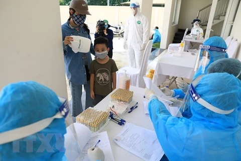 Медицинские работники проводят экспресс-тест на COVID-19 у людей, вернувшихся из районов эпидемии. (Фото: ВИА)