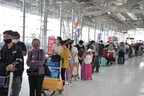 Вьетнамские граждане стоят в очереди для выполнения необходимых процедур перед посадкой на самолет домой. (Фото: ВИА).