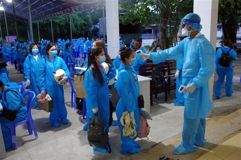 Медсестра измеряет температуру тела людей, находящихся в карантинной зоне провинции Шокчанг. (Фото: ВИА)