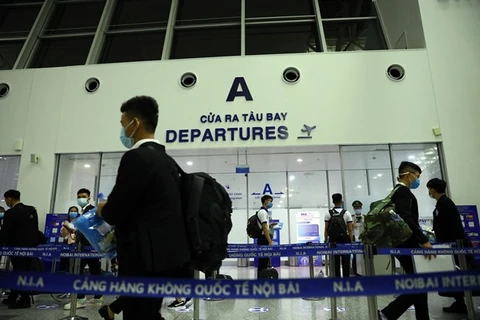 Пассажиры ждут, чтобы пройти процедуры посадки в международном аэропорту Нойбай в Ханое (Фото: ВИА)