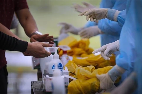 Граждане Вьетнама моют руки дезинфицирующими средствами при входе в зону концентрированного карантина (Источник: ВИА)