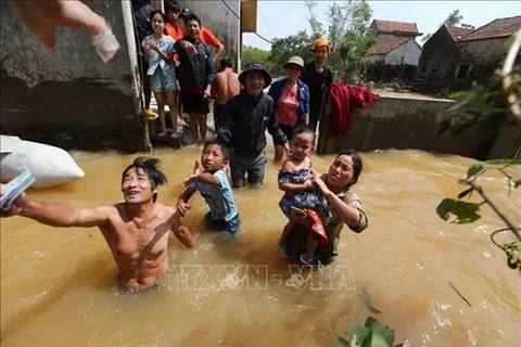 Жители района Летхуи центральной провинции Куангбинь получают помощь от наводнения (Фото: ВИА)
