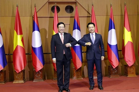Заместитель премьер-министра, министр иностранных дел Вьетнама Фам Бинь Минь (слева) и министр иностранных дел Лаоса Салеумсай Коммасит (Фото: ВИА)