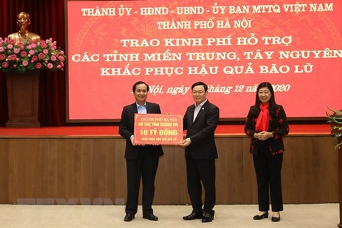 Секретарь партийного комитета Ханоя Выонг Динь Хюэ (в центре) дарит Куангчи 10 млрд. донгов (Источник: ВИА)
