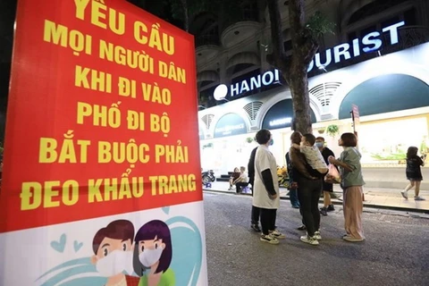 Людей, гуляющих по пешеходным улицам в центре Ханоя, просят использовать маски (Фото: ВИА)