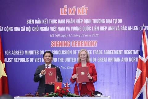 Министр промышленности и торговли Чан Туан Ань и госсекретарь Великобритании по международной торговле Элизабет Трасс подписывают протокол о завершении переговоров по UKVFTA. (Фото: ВИА)